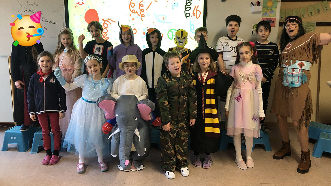 Gruppenfoto fantasievoll kostümierter Kinder und Lehrerin